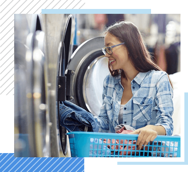 Young maid or housekeeper washing clothes in automatic machine